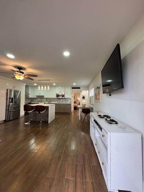A modern open-concept kitchen and living area features wood-look tile flooring and a white console — 187 Seville Terrace, Delray Beach FL 33446, DELRAY BEACH, FL