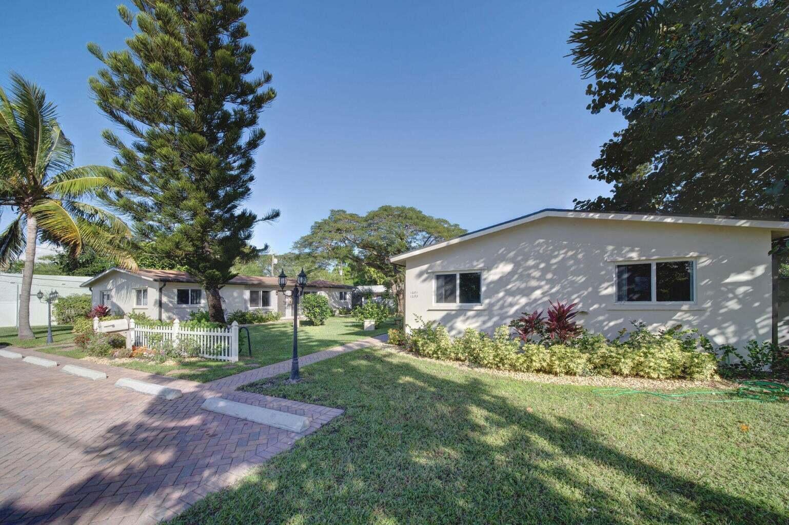 A view of two single-story residential buildings with white walls and a brick driveway — 1201 NE 2nd Avenue, Delray Beach FL 33444, DELRAY BEACH, FL