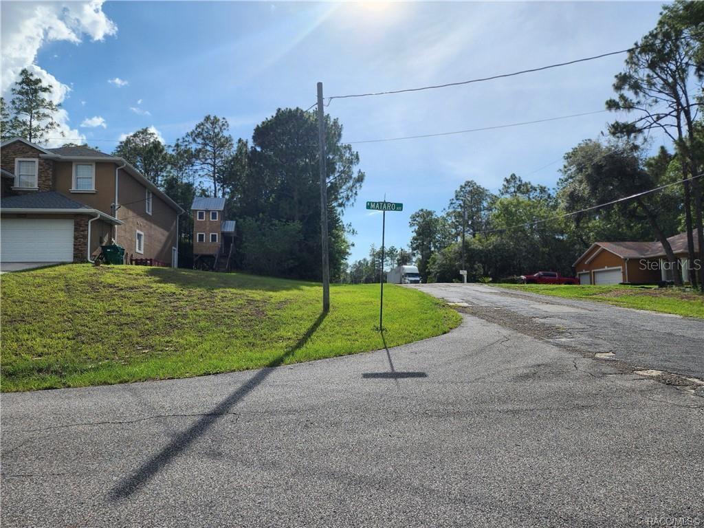 A street corner with a sign for Mataro Avenue, a house, and trees under a sunny sky — 11107 N MATARO AVENUE, CITRUS SPRINGS, FL