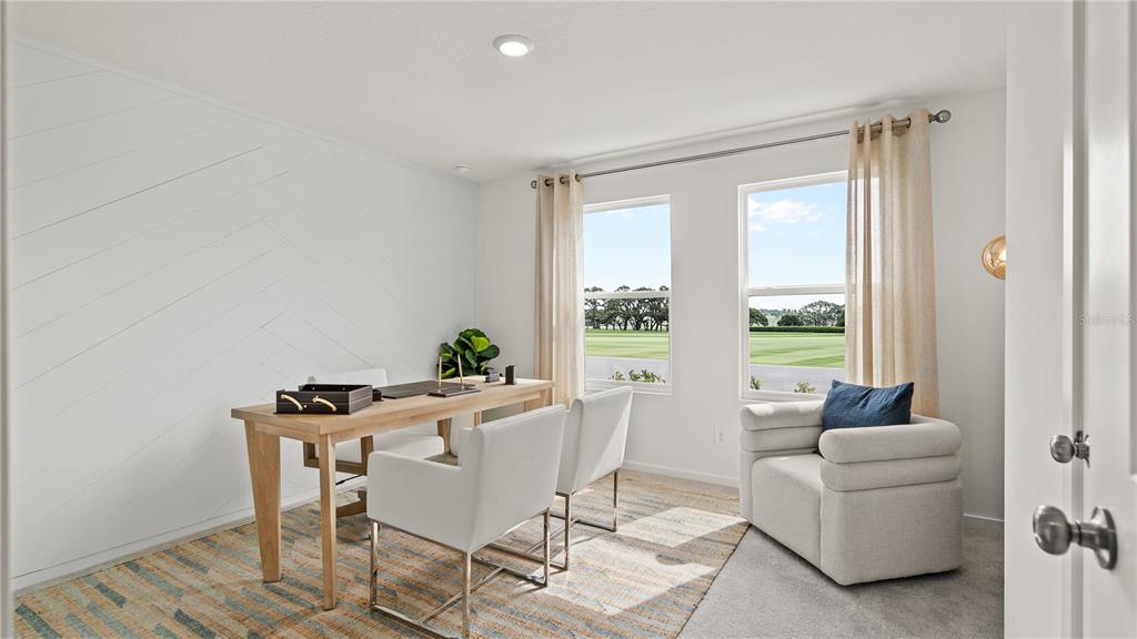 A home office features a light wood desk, white chairs, and a patterned rug — 717 RUTH AVENUE, HAINES CITY, FL