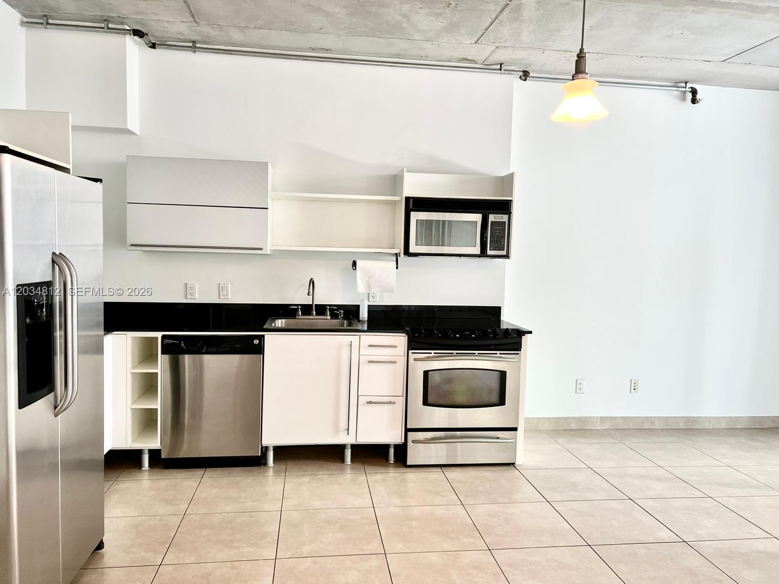 A modern kitchen features stainless steel appliances, white cabinetry, and a concrete ceiling — 690 SW 1st Ct # 1026, Miami FL 33130, MIAMI, FL