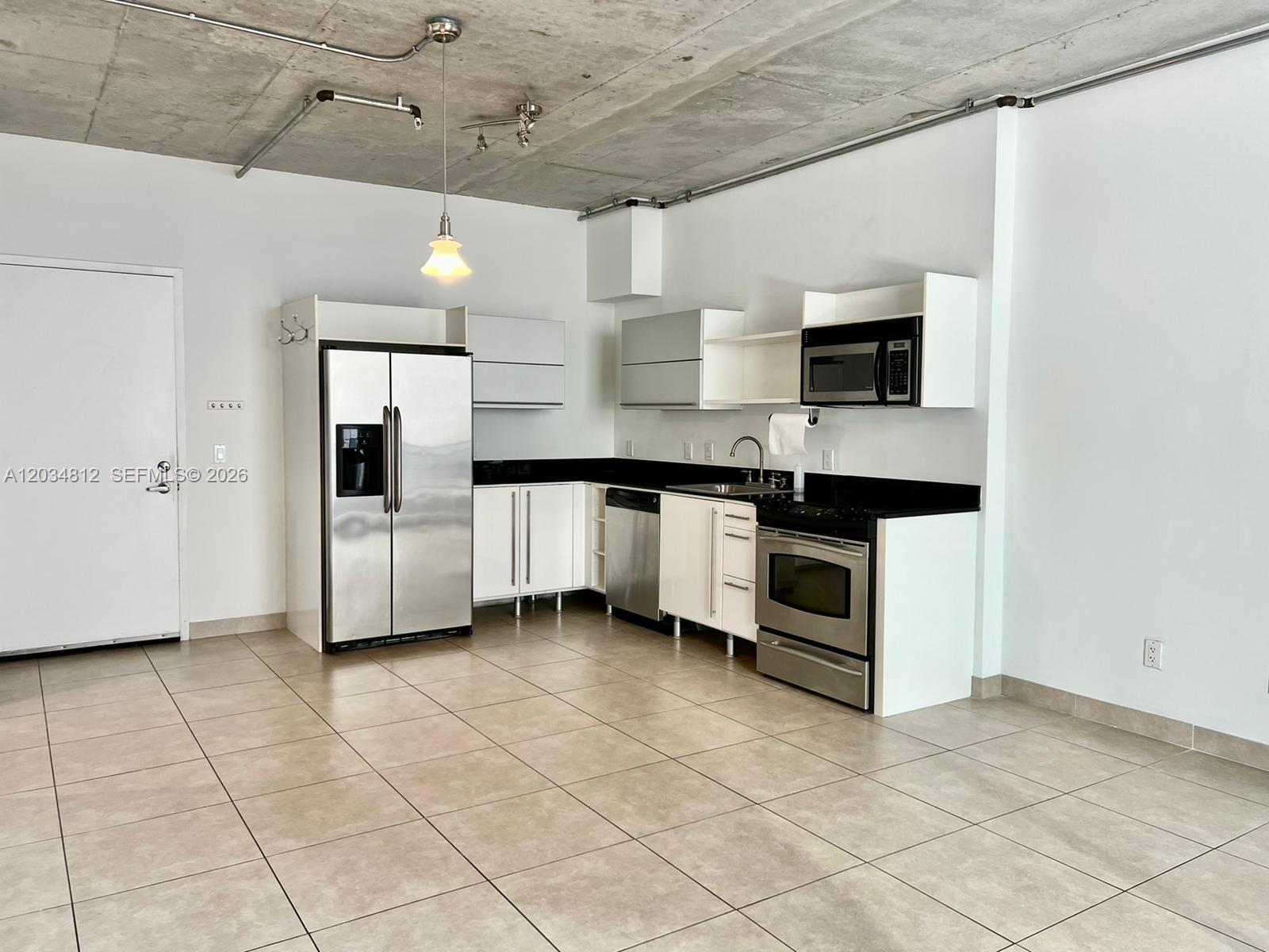 A kitchen with stainless steel appliances, white cabinets, and a concrete ceiling in an open space — 690 SW 1st Ct # 1026, Miami FL 33130, MIAMI, FL