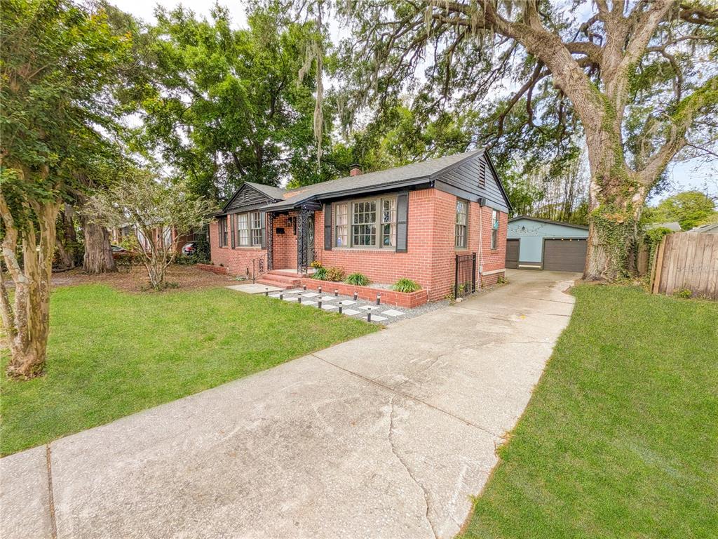 A single-story red brick house with a concrete driveway and a detached garage — 4224 REDWOOD AVENUE, JACKSONVILLE, FL