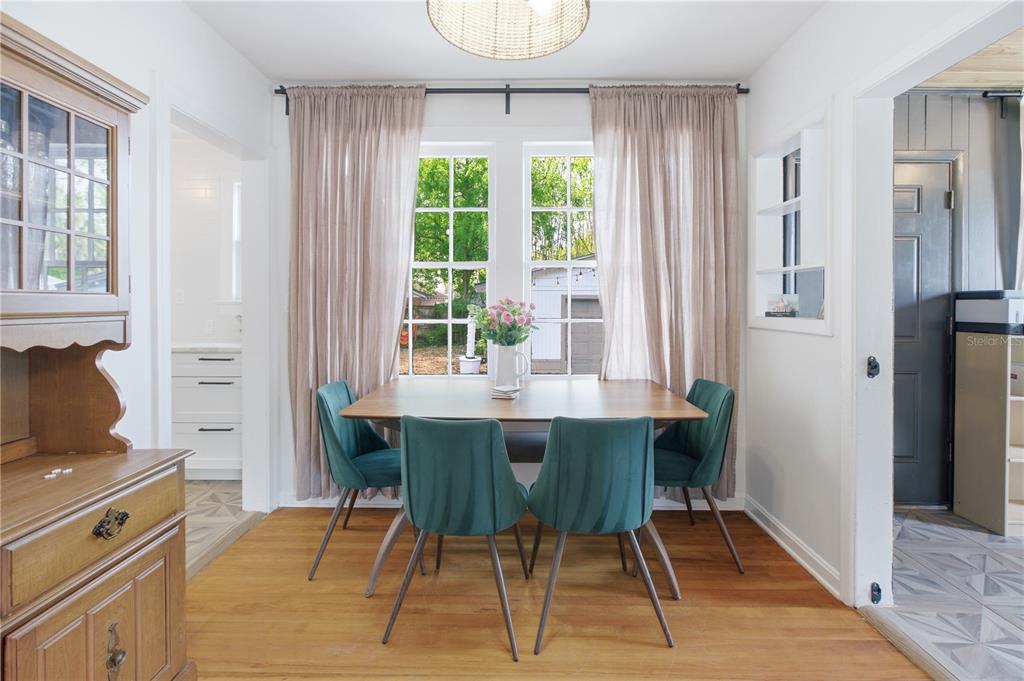 A dining room features a wooden table, four teal chairs, and windows with sheer curtains — 4224 REDWOOD AVENUE, JACKSONVILLE, FL