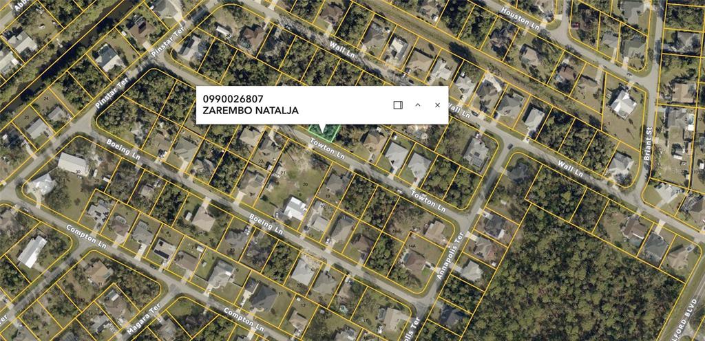 This is an aerial map view of a residential neighborhood showing property lot lines — TOWTON LANE, NORTH PORT, FL