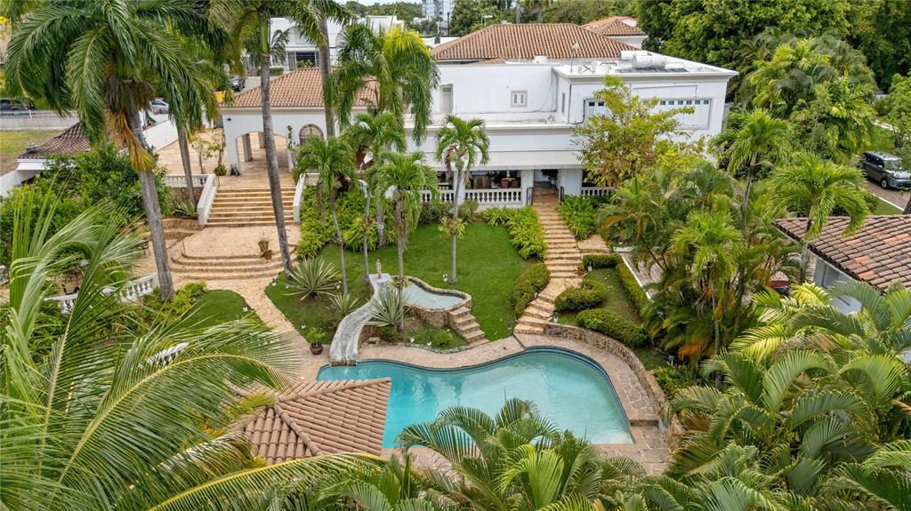 An aerial view of a white multi-story house with a pool, fountain, and palm trees — A Street VILLA CAPARRA UNIT A-13, GUAYNABO, PR