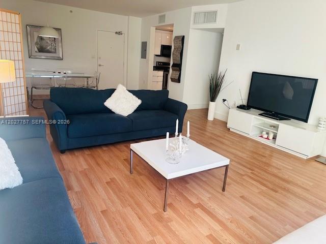 A living room features a blue sofa, a white coffee table, and a television console — 10275 Collins Ave # 223, Bal Harbour FL 33154, BAL HARBOUR, FL