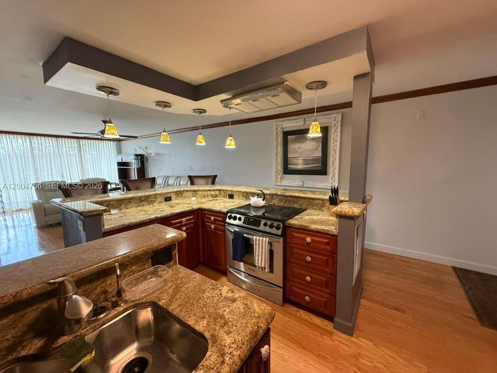 A kitchen with granite countertops, stainless steel appliances, and a breakfast bar — 2691 S Course Dr # 202, Pompano Beach FL 33069, POMPANO BEACH, FL