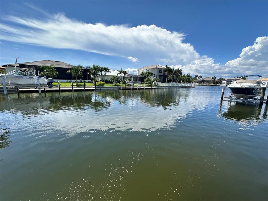 A canal view shows two boats docked at private piers in front of waterfront homes — 3611 BONAIRE COURT, PUNTA GORDA, FL