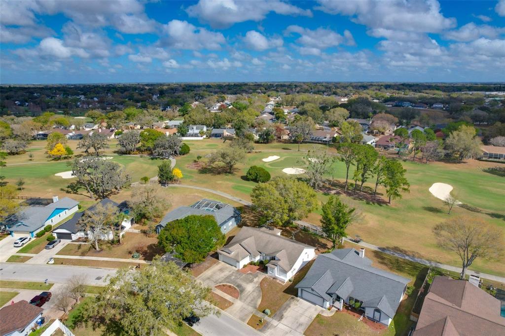 An aerial view shows several suburban houses bordering a golf course with sand traps — 2626 CRESTFIELD DRIVE, VALRICO, FL