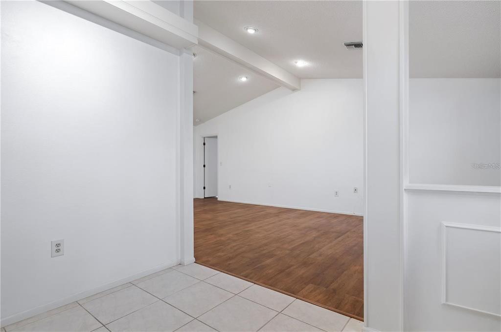 A view from a tiled entryway into a living area with wood-look flooring — 133 1ST AVENUE, NOKOMIS, FL
