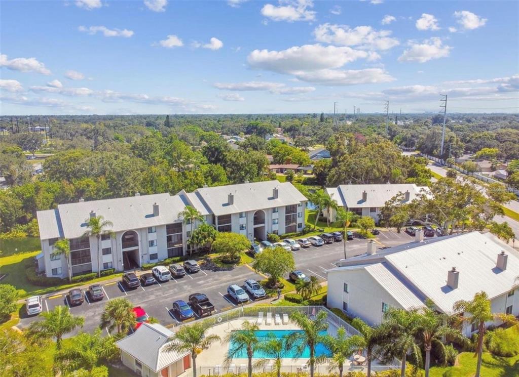 An aerial view of an apartment complex with a swimming pool and parking lot — 2067 HUNTERS GLEN DRIVE UNIT 312, DUNEDIN, FL