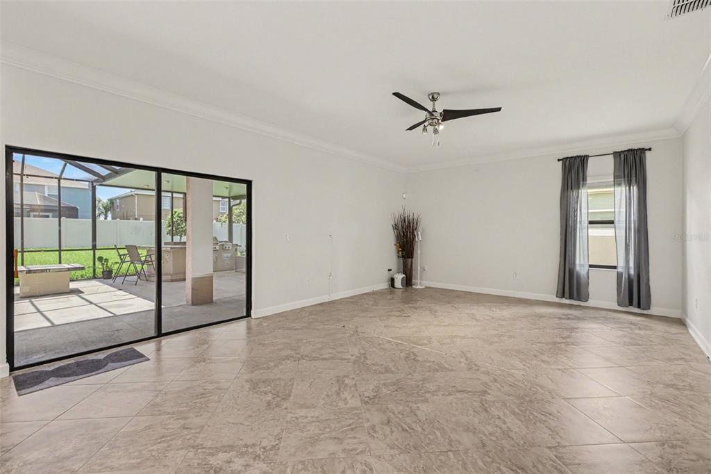 This is a virtually staged living room with tile floors, a ceiling fan, and furniture — 12005 CINNAMON FERN DRIVE, RIVERVIEW, FL