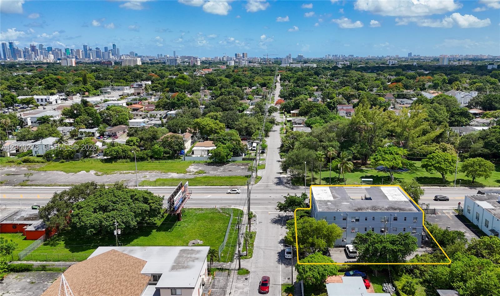 An aerial view shows a multi-story apartment building outlined in yellow near a busy intersection — 1801 NW 54th St, Miami FL 33142, MIAMI, FL