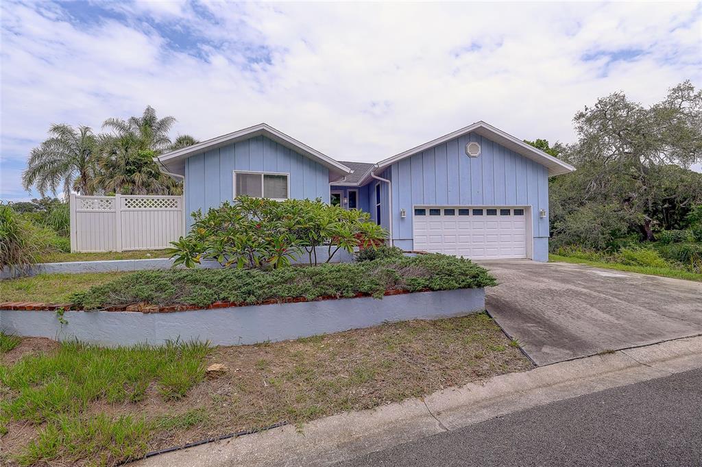 An aerial view shows a light blue house with a deck overlooking a river — 3214 N SECLUSION DRIVE, SARASOTA, FL
