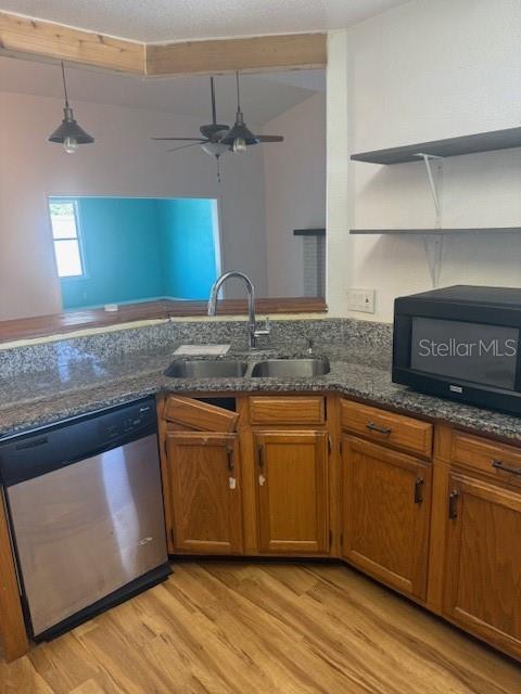 A kitchen features wood cabinets, granite countertops, a stainless steel dishwasher, and a black microwave — 3620 SAWGRASS DRIVE, TITUSVILLE, FL