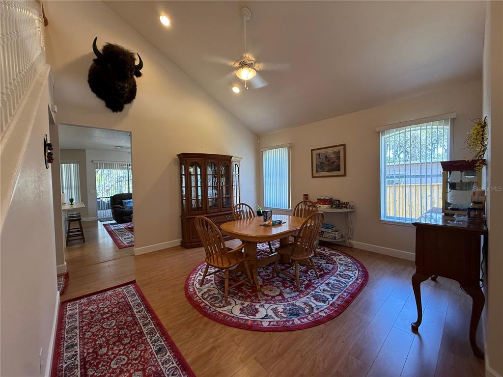 A dining room with a wooden table, chairs, a hutch, and a buffalo wall mount — 24907 NE 135TH STREET, SALT SPRINGS, FL