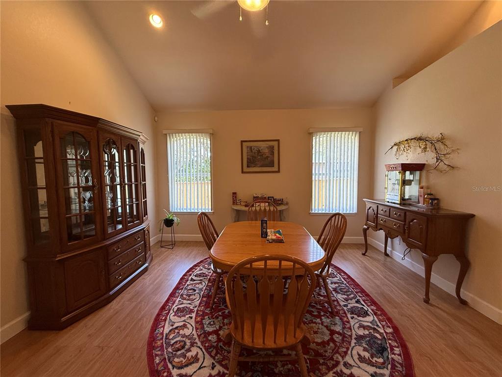 A dining room features a wooden table, chairs, a hutch, and a patterned area rug — 24907 NE 135TH STREET, SALT SPRINGS, FL
