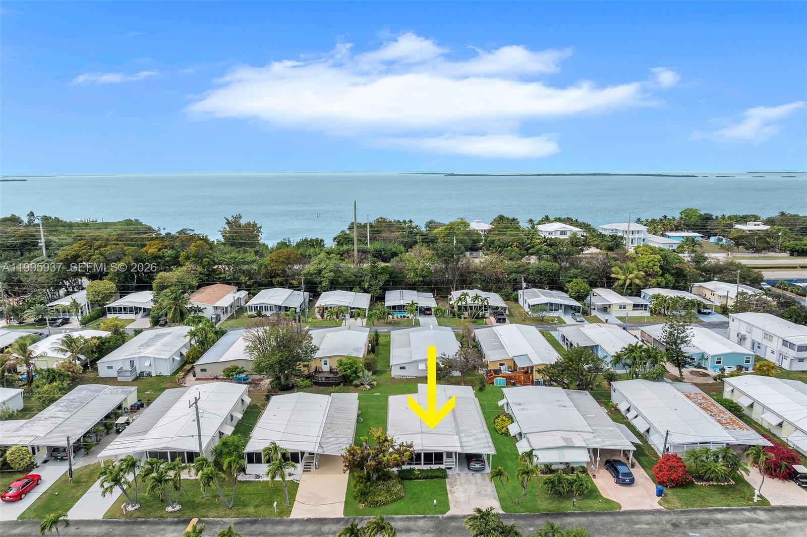 An aerial view shows a single-story house with a yellow arrow pointing to its roof — 812 S Silver Cir, Key Largo FL 33037, KEY LARGO, FL