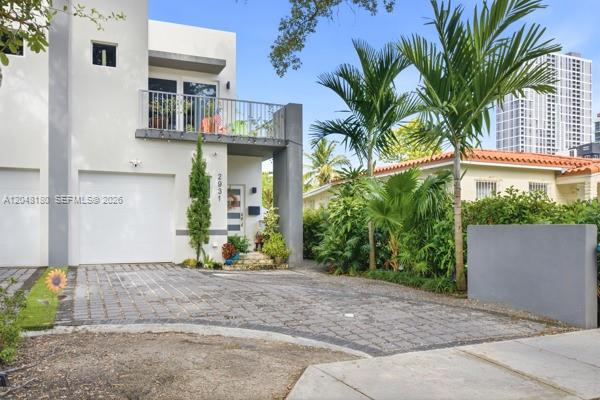 A modern two-story house features a paved driveway, a white garage door, and a balcony — 2931 SW 38th Ct # 2, Miami FL 33134, MIAMI, FL