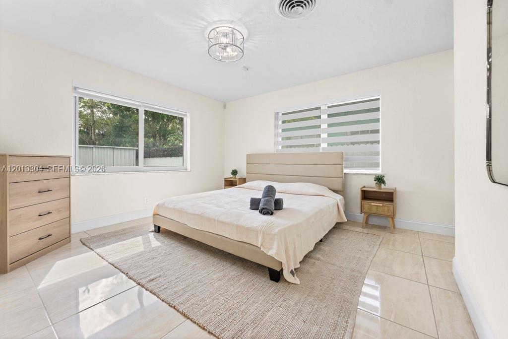 A bedroom features a beige bed, two nightstands, a dresser, and tile flooring — 2128 Dock St # 0, West Palm Beach FL 33401, WEST PALM BEACH, FL