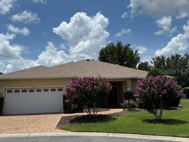 A single-story house with a two-car garage and two blooming crape myrtle trees in front — 8835 SW 83RD COURT ROAD, OCALA, FL