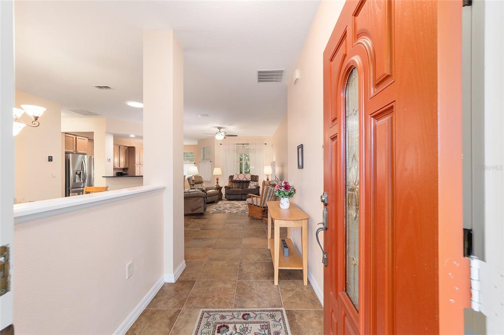 An entryway with tile flooring leads into a living room and kitchen area — 8835 SW 83RD COURT ROAD, OCALA, FL