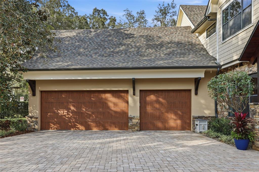A two-car garage with wood-look doors and a paver driveway in front of a house — 713 MAIN STREET, WINDERMERE, FL