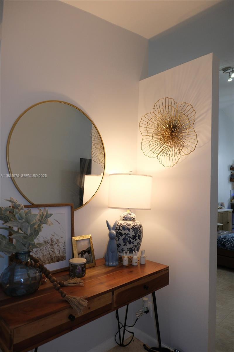 A wooden console table sits against a wall with a mirror, lamp, and floral decor — 1021 NW 79th Ave, Plantation FL 33322, PLANTATION, FL