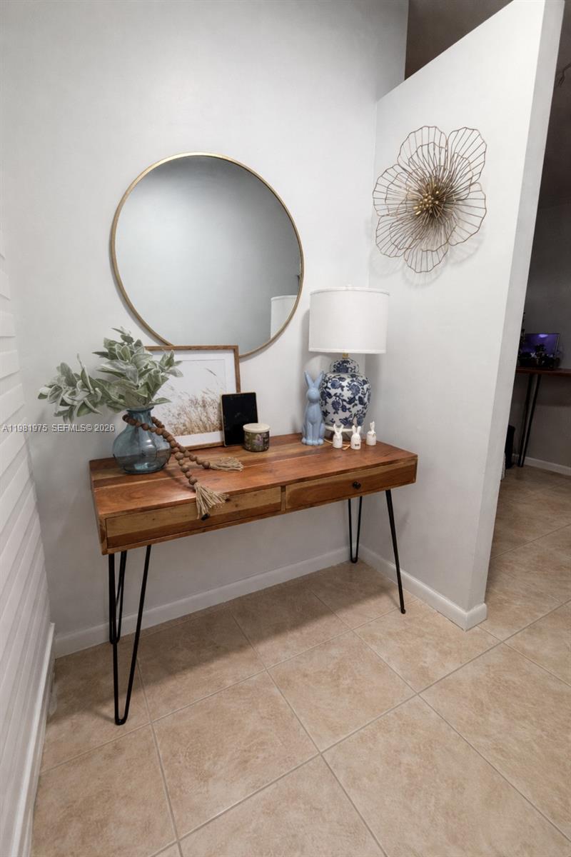 A wooden console table with hairpin legs sits against a wall beneath a round mirror — 1021 NW 79th Ave, Plantation FL 33322, PLANTATION, FL