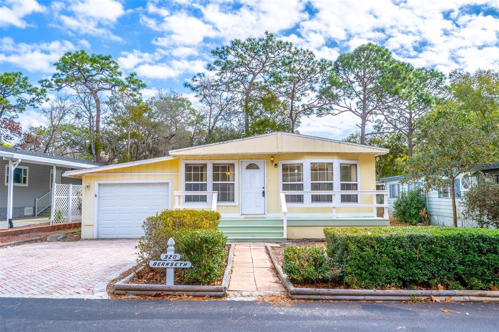 A yellow single-story house with a garage, front porch, and landscaped yard — 320 N FOREST BOULEVARD, LAKE MARY, FL