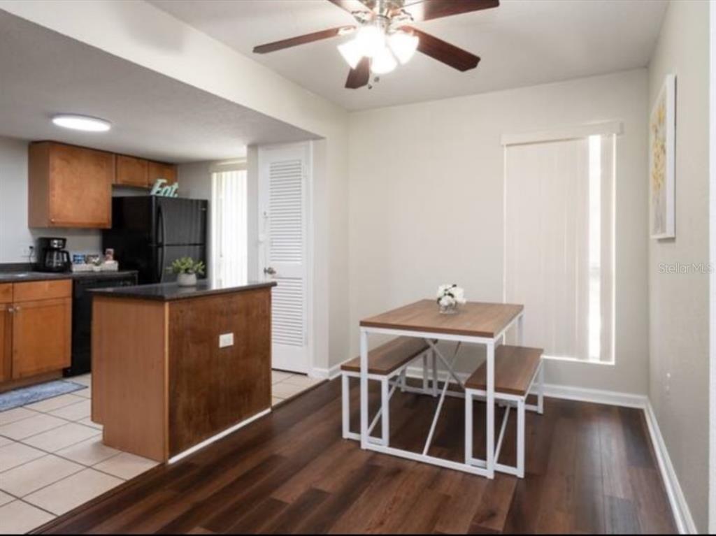 A dining area with a wood-topped table and benches sits next to a kitchen island — 1810 NW 23RD BOULEVARD UNIT 178, GAINESVILLE, FL