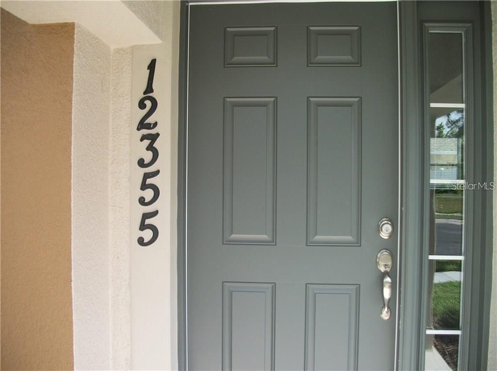 A gray front door with a vertical house number display and a side window panel — 12355 LANGSTAFF DRIVE, WINDERMERE, FL