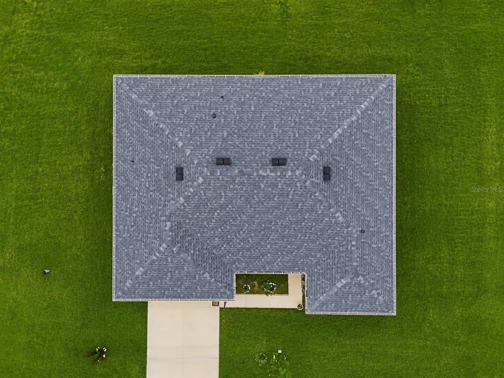 An aerial view shows a house with a gray shingled roof surrounded by green grass — 15943 SW 53RD COURT, OCALA, FL