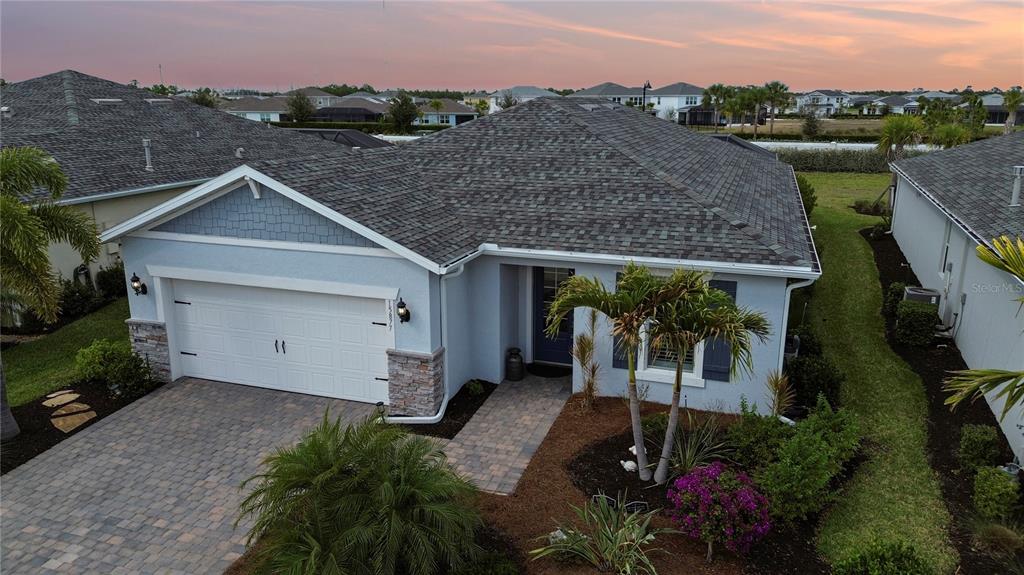 An exterior view of a light blue single-story house with a paved driveway and roof — 15877 SHORELINE DRIVE, PUNTA GORDA, FL