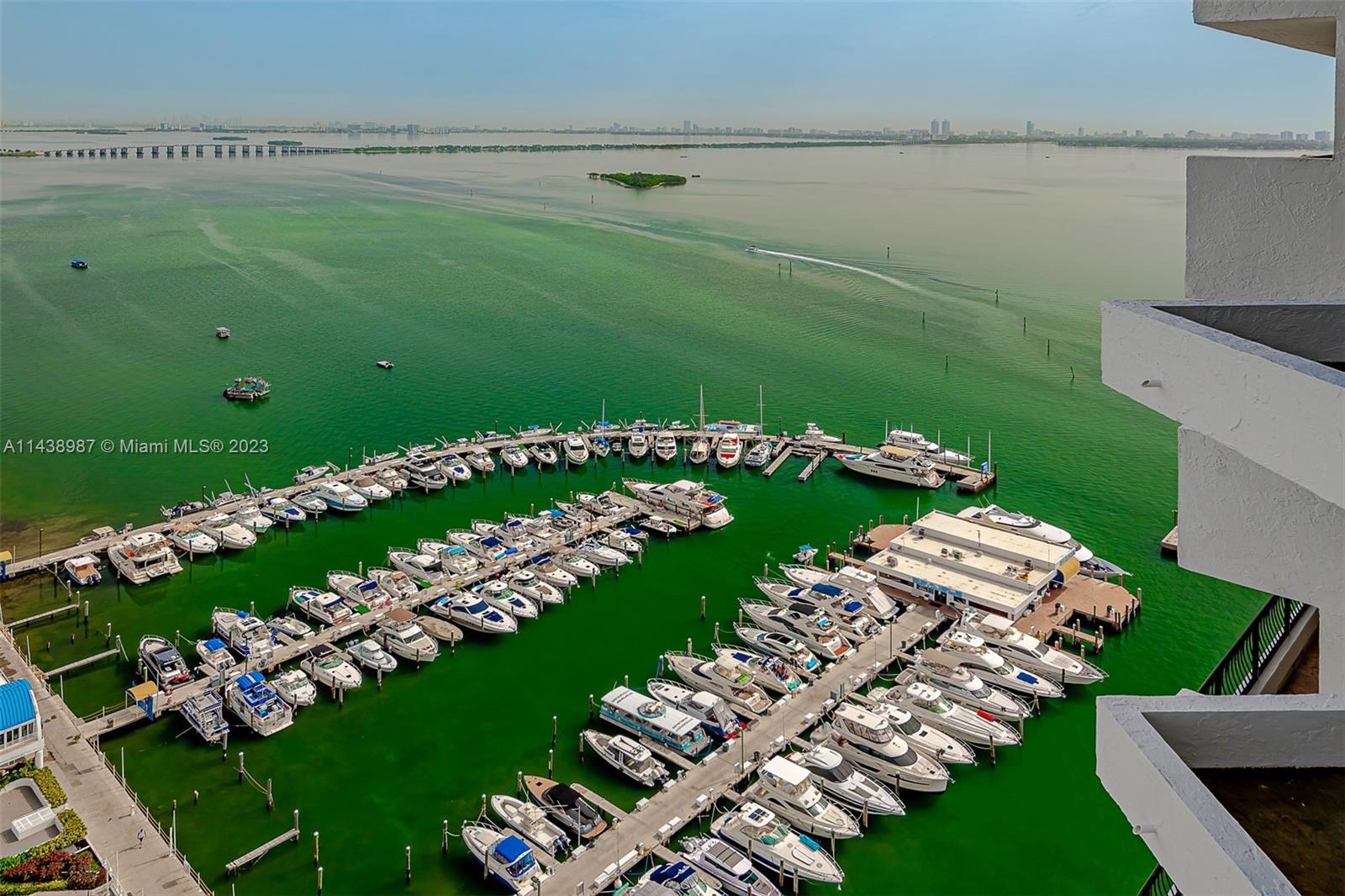 An elevated view shows a marina filled with boats on green water near a building — 555 NE 15th St # 32E, Miami FL 33132, MIAMI, FL