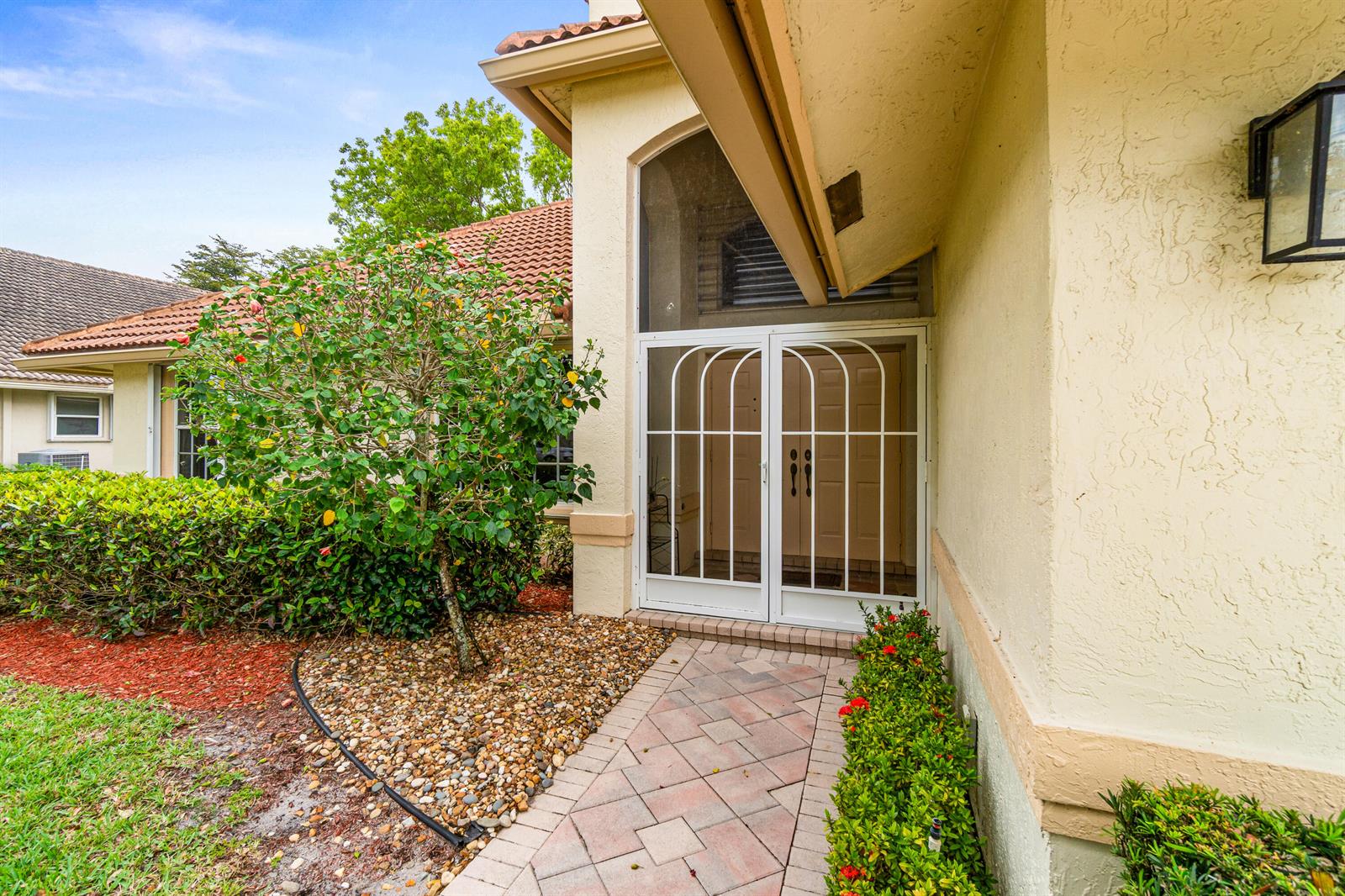 A paved walkway leads to a white double screen door at the home's front entrance — 6952 Grenelefe Road, Boynton Beach FL 33437, BOYNTON BEACH, FL