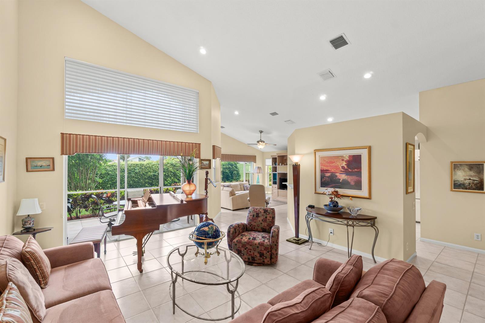 A living room features a grand piano, tile floors, vaulted ceilings, and a glass coffee table — 6952 Grenelefe Road, Boynton Beach FL 33437, BOYNTON BEACH, FL
