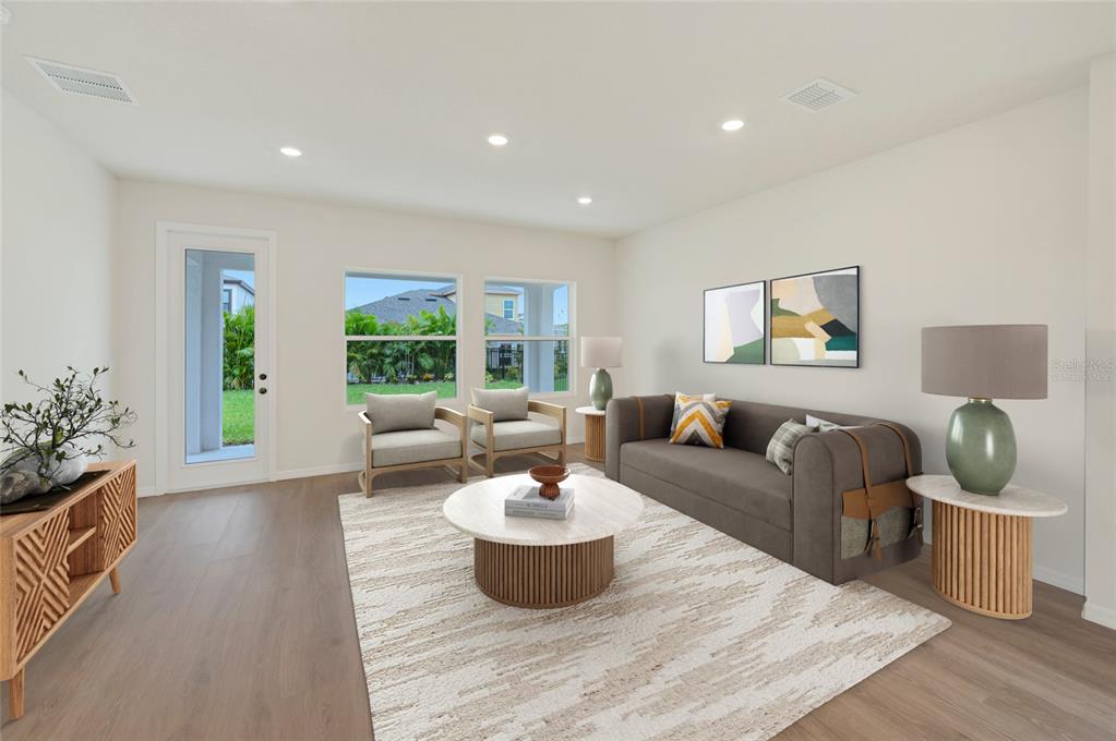 This is a digital rendering of a living room featuring a sofa, chairs, and coffee table — 5024 CHAPEL ROW AVENUE, APOLLO BEACH, FL