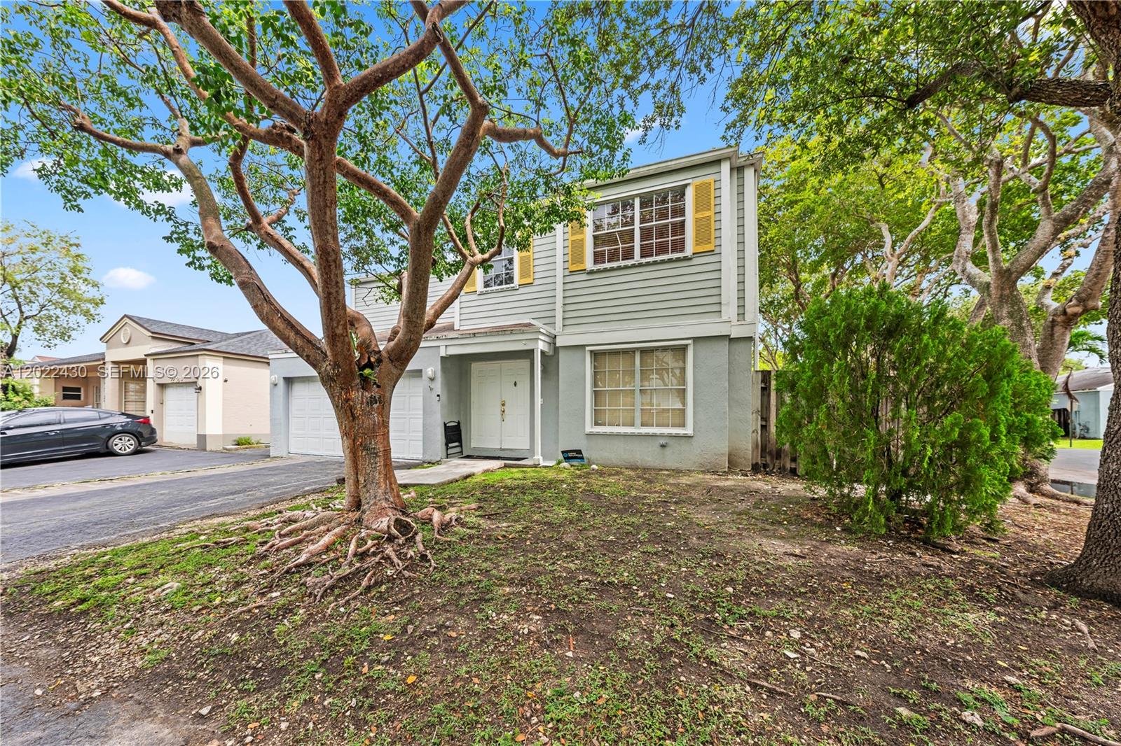 A two-story house with light gray siding, a double garage, and a large front tree — 22316 SW 99th Ave, Cutler Bay FL 33190, CUTLER BAY, FL