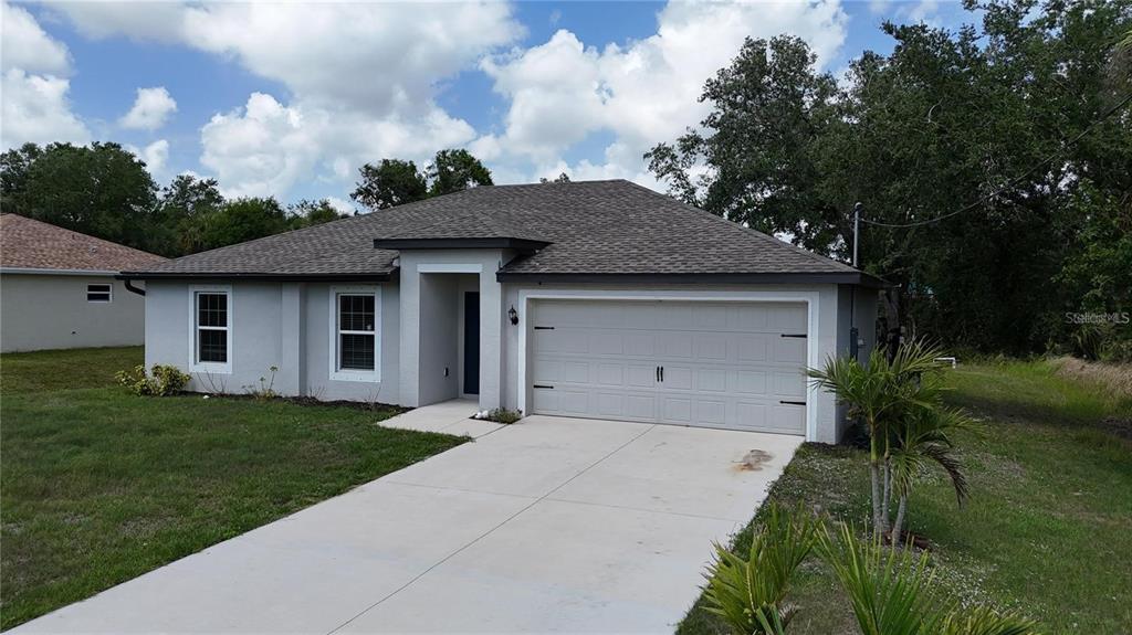 A single-story house with a light gray exterior, a two-car garage, and a concrete driveway — 4127 SNOWDROP STREET, NORTH PORT, FL