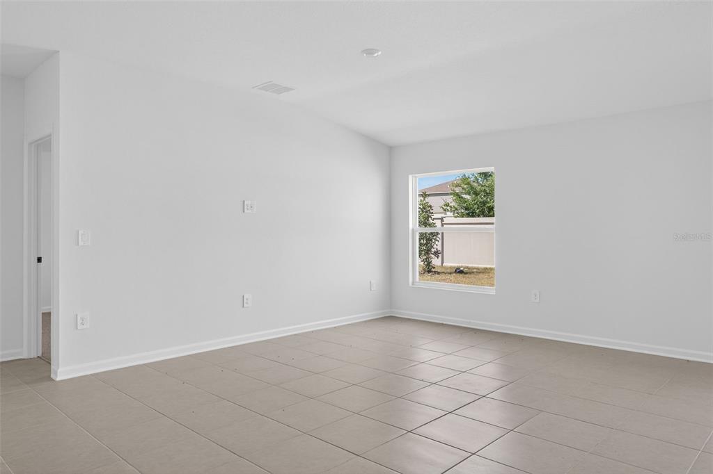 An empty room with light-colored walls, tile flooring, and a single window — 5161 GREEN BELT DRIVE, HAINES CITY, FL