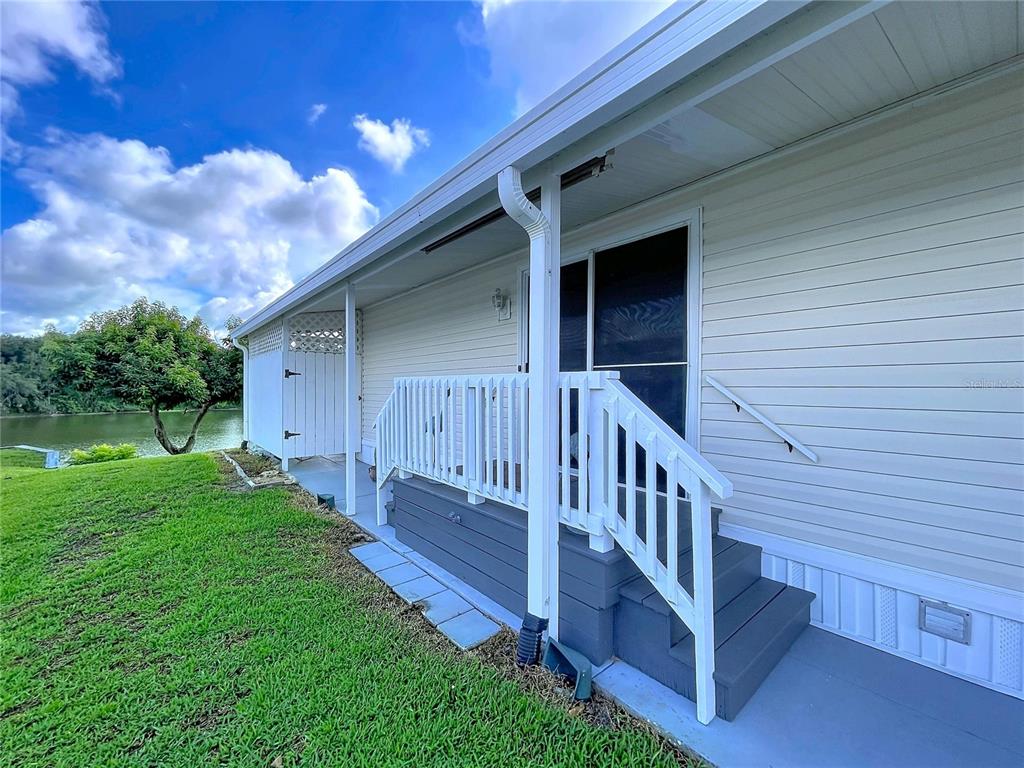 An aerial view shows a swimming pool with a patio and a clubhouse building — 2055 S FLORAL AVENUE UNIT 192, BARTOW, FL