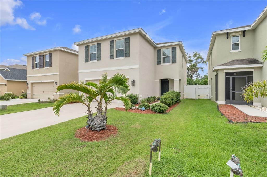 A two-story suburban house with a palm tree in the front yard and green lawn — 4110 WILLOW HAMMOCK DR, PALMETTO, FL