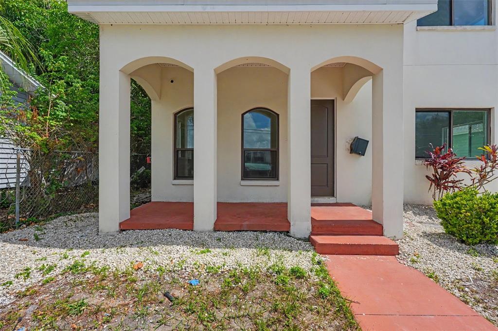 The exterior of a house features a covered porch with three arched openings and steps — 1018 7TH AVENUE S UNIT R, ST PETERSBURG, FL