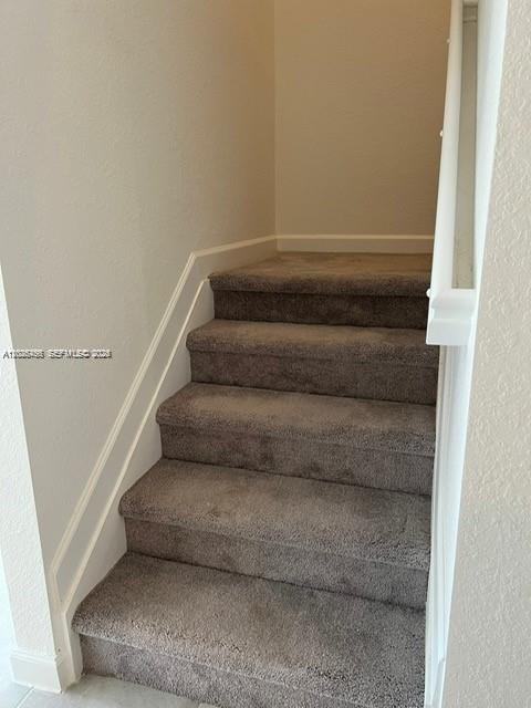 A set of carpeted stairs leads upward between two light-colored walls — 12663 NW 24th Ave, Miami FL 33167, MIAMI, FL