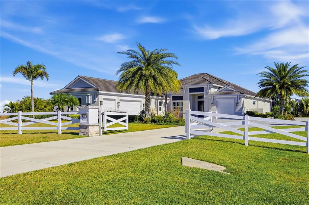 A single-story house with a white fence, palm trees, and a concrete driveway — 3467 COMPOUND COURT, SARASOTA, FL