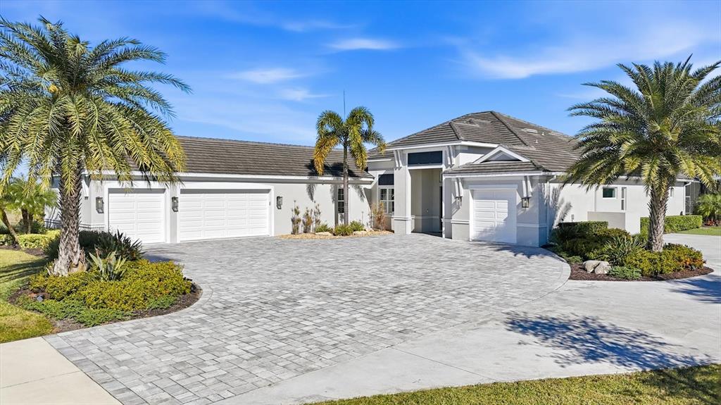 A single-story house with a paved driveway, three garage bays, and several palm trees — 3467 COMPOUND COURT, SARASOTA, FL