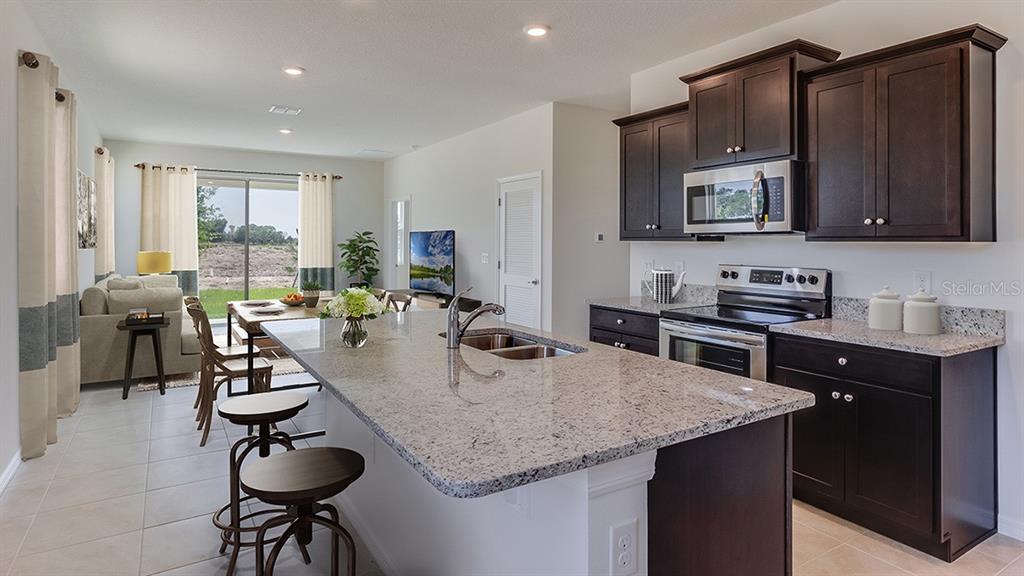This is a rendering of an open-concept living and dining area with light wood flooring — 4603 SW 71ST LANE ROAD, OCALA, FL