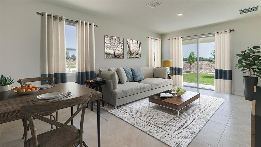 A modern kitchen features white cabinetry, a central island with a sink, and stainless appliances — 4603 SW 71ST LANE ROAD, OCALA, FL